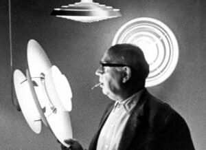 Poul Henningsen is holding a PH 5 pendant lamp and has a cigarette in his mouth